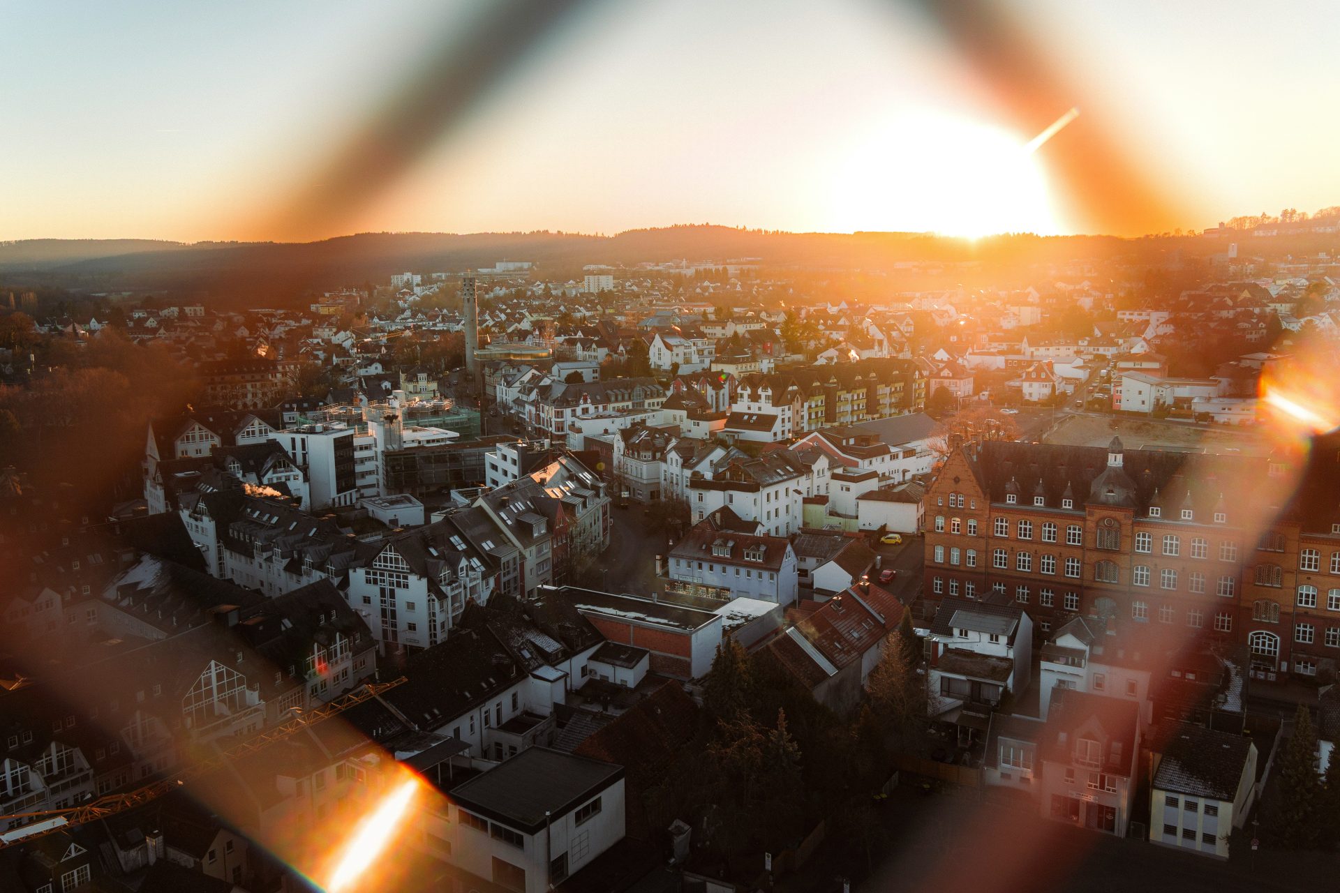 Sonnenuntergang über einer europäischen Stadt mit Lichtreflexen.